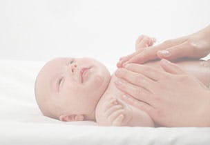 mums hands massaging newborn baby's chest