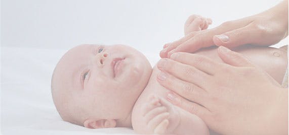 mums hands massaging newborn baby's chest